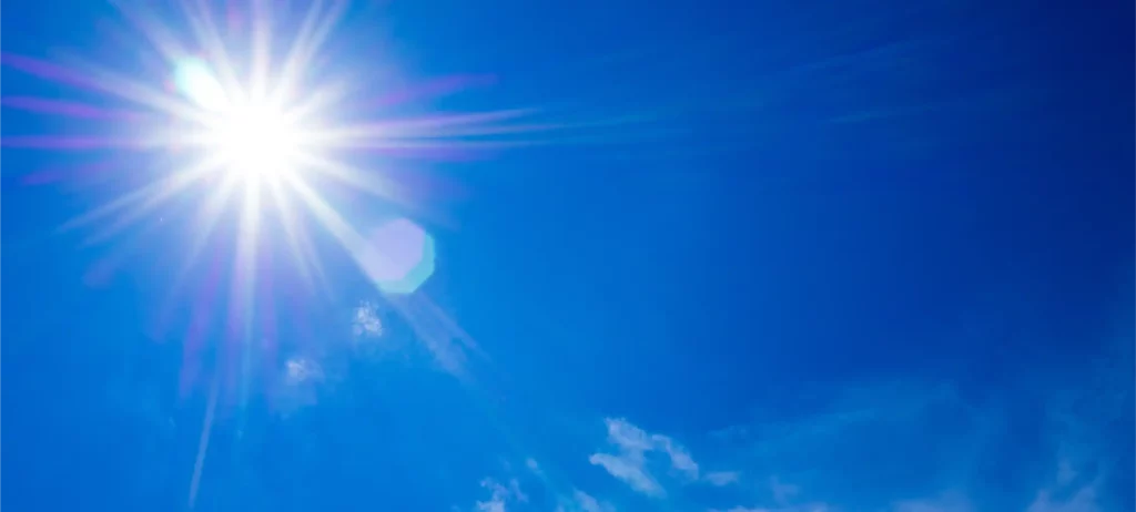 Rayons du soleil dans un ciel bleu illustrant la production naturelle de vitamine D3 par exposition solaire